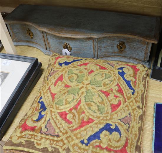 A three drawer serpentine table top cabinet and a woolwork cushion